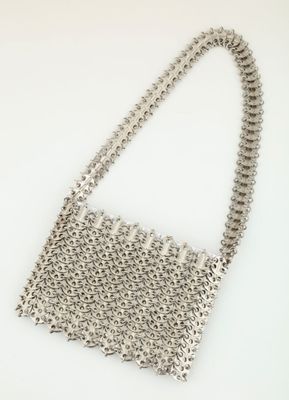 a close up of a silver purse on a white surface