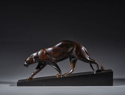 une photo d'une sculpture en bronze représentant un tigre sur un socle noir