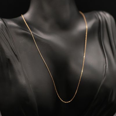 a woman wearing a black dress and gold chain necklace