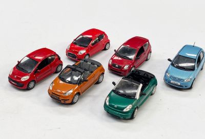 plusieurs petites voitures sont alignées sur une surface blanche