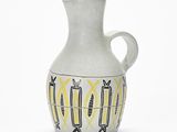 a white vase with yellow and black designs on it