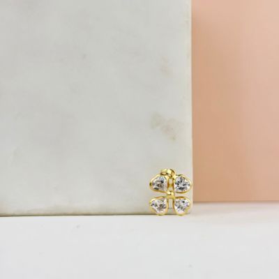 une paire de boucles d'oreilles en or et en diamants posée sur un bloc de marbre