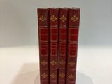 three red books sitting on top of each other on a table