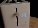a clock on the side of a toaster on a table