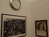 une horloge accrochée au mur au-dessus d'un portrait de femme
