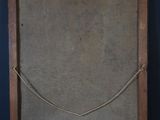 an old wooden frame with a rope hanging on the wall