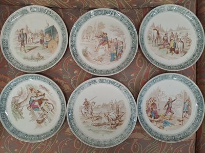 six assiettes ornées d'images de personnes et d'animaux, posées sur une table