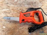 an orange and black corded electric saw on a wooden surface