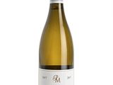 a bottle of white wine sitting on top of a white table