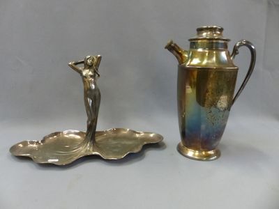 une théière en argent et une assiette en argent posées sur une table