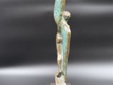 a bronze statue of a man holding a bird on a wooden base