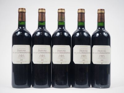 quatre bouteilles de vin sont alignées sur une surface blanche