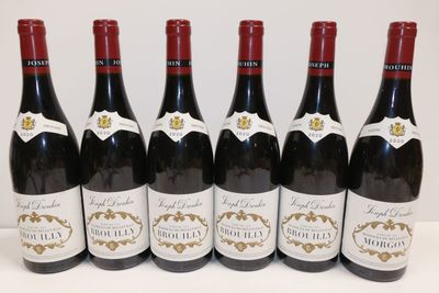six bouteilles de vin rouge sont alignées sur une table