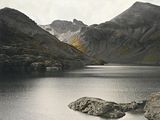 a large body of water with a mountain in the background
