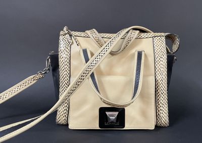 an image of a beige and black purse with a black and white strap
