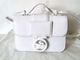 un sac blanc orné d'un logo, posé sur un oreiller
