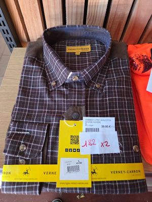 two shirts that are sitting on a wooden table