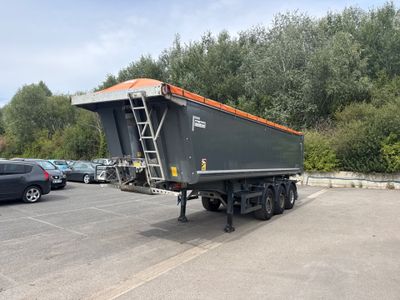 une photo d'un camion-benne garé sur un parking