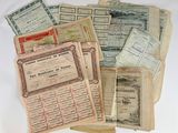several old paper certificates are stacked on top of each other