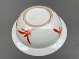 a white bowl with a red design on it