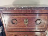 a wooden chest of drawers with brass knobs on it