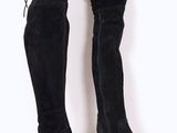 bottes noires en daim montant au-dessus du genou, avec des lacets au talon