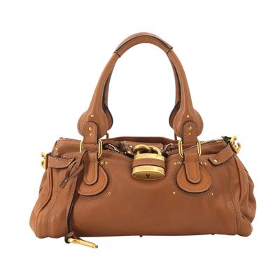 a brown leather handbag with a gold lock on the handle