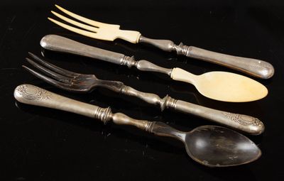 four forks and a spoon on a black table