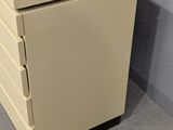a beige filing cabinet with four drawers in the corner