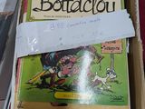une boîte de bandes dessinées posée sur une table à côté d'une paire de chaussures