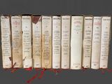 plusieurs vieux livres sont alignés sur une surface grise