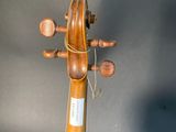 an old violin is sitting on a stand against a black background