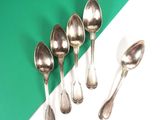 five spoons and a spoon spoon on a green and white surface