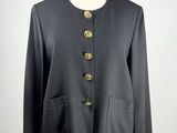 a black jacket with gold buttons on a mannequin torso