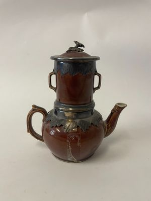 a brown tea pot with a lid on a white table