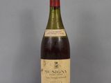 an old bottle of wine sitting on top of a glass table