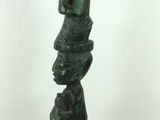 a tall green sculpture made of rocks on a white surface