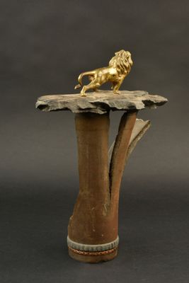 une statue en or représentant un lion posée sur une table en bois