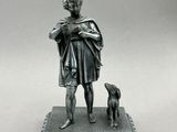 une statue en argent représentant un homme avec un chien, posée sur un socle