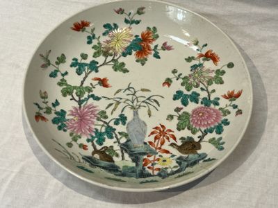 une assiette décorée de fleurs et d'oiseaux, posée sur une table
