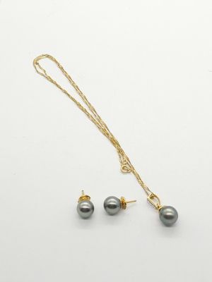 a necklace and earring set with grey pearls on a white background