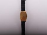 a close up of a watch on a white surface with a black strap