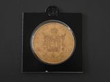 an image of a gold coin in a black box on a black surface