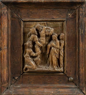 un vieux cadre en bois sur lequel est sculpté un groupe de personnes