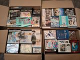 un grand nombre de dvd dans une boîte posée sur le sol