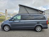 the van is parked in the parking lot with the roof up