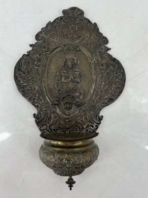 an antique brass plate with a picture of the virgin of guadalupe on it