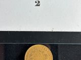 an image of a gold coin sitting on top of a black table