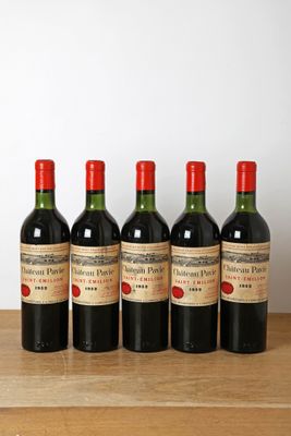 six bouteilles de vin rouge alignées sur une table en bois