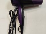 purple and black hair dryer sitting on top of a white table